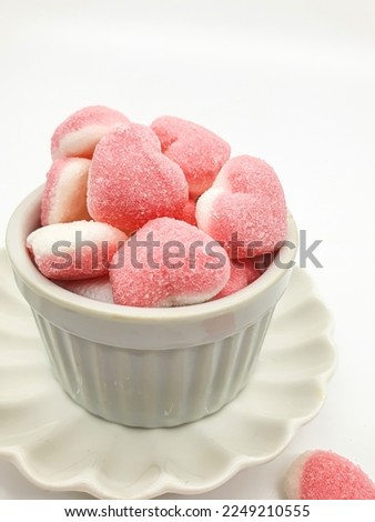 Selective focus of heart shaped Jelly candy covered in sugar on white background