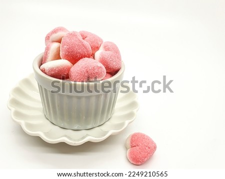 Selective focus of heart shaped Jelly candy covered in sugar on white background