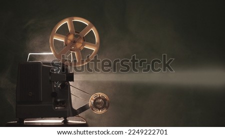 Old retro film projector light beam in the dark Royalty-Free Stock Photo #2249222701