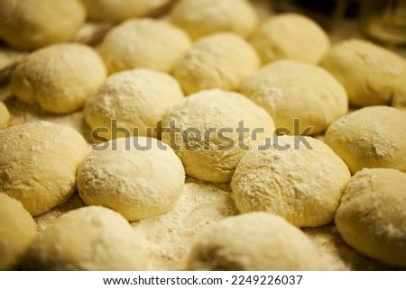 Close-up photo of dough products. Small round products sprinkled with flour. Horizontal photo.