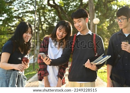 Diverse young college friends talking to etch other while walking after classes in university campus outdoors