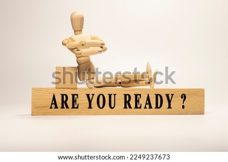 Are you ready text. It is written on a wooden surface. The background is white..