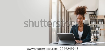 Young African American female working with tablet computer on remote project watching webinar. doing corporate data digital technology analysis.