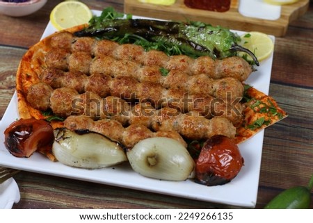 Close up of Skewered Beef Kebab Serving Plate with Grilled Tomato Onion and Pepper Slices
