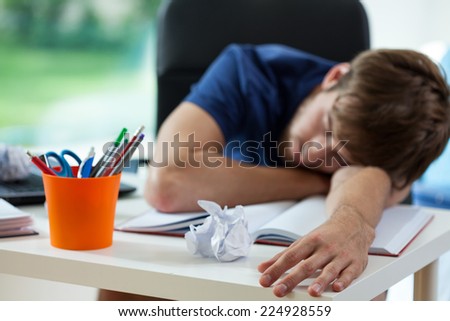 Tired student fall asleep during preparation to exams  