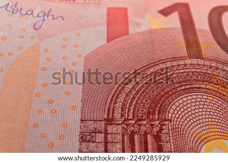 A macro image of the red microprint, sign, watermark on a Ten Euro banknote, emphasizing the advanced tamper-proof technology used to protect against fraud.