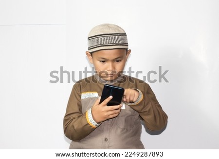 asian muslim boy using phone