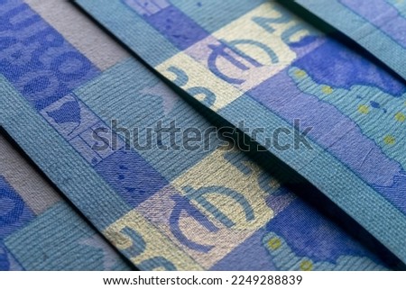 A macro image of the special fluorescence ink and holographic features on a 20 Euro banknote, showcasing the security measures in place to prevent counterfeiting.