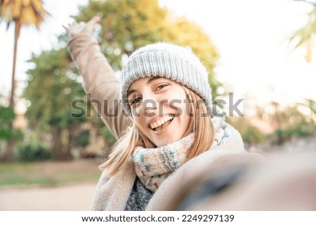 Young woman taking selfie on the street having fun in winter day