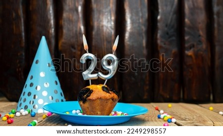 Beautiful anniversary background happy birthday with a cupcake and a burning candle. Happy birthday anniversary on wooden background with decorations with number 29