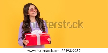 Child girl gift. stylish teen girl in jacket and eyeglasses hold gift box. shopping time. Kid girl with gift, horizontal poster. Banner header with copy space.