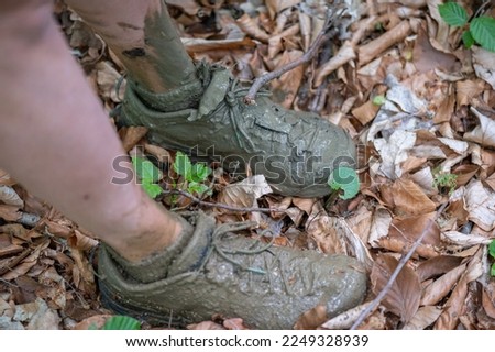 women's shoes and feet from wet dirty mud and dirt after crossing a muddy stream in the beech forrest