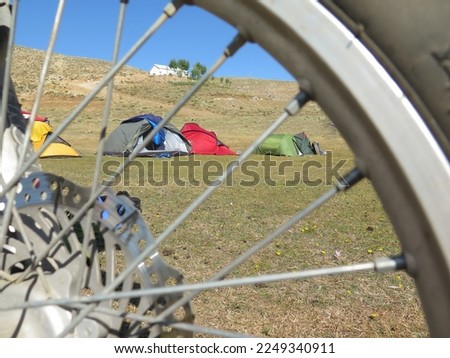camping tent photo from behind motorcycle rim