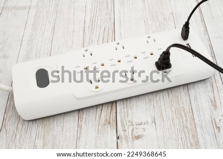 Black surge and ground protector with USB protection on weathered wood Royalty-Free Stock Photo #2249368645