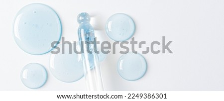 Drops of cosmetic serum and a pipette. A skin care product. White background. Copy space. Royalty-Free Stock Photo #2249386301