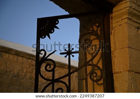 Traditional handcrafted wrought iron main entrance gate of Aghioi Theodoroi a picturesque Greek Orthodox church in Plakakia beach, Aegina island Greece. 