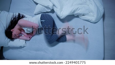 Woman With RLS - Restless Legs Syndrome. Sleeping In Bed Royalty-Free Stock Photo #2249401775