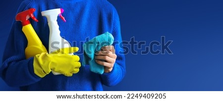 Charwoman standing with a bucket and cleaning products on blurred office background. Royalty-Free Stock Photo #2249409205