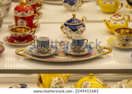 Traditional Turkish coffee mugs with a pot, decorative porcelain cups, colorful retro mug and teapot in gift shop in Istanbul, blue white cultural tea set