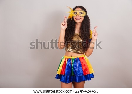 young teen girl, brazilian, with frevo clothes, carnival. mask, fingers crossed, sign of luck.