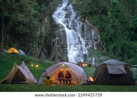 asian woman traveller in Light and campfire on night time at Mae tia waterfall near Doi inthanon in Chiang mai, Northen, Thailand Royalty-Free Stock Photo #2249425739