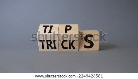 Tips and Tricks symbol. Wooden cubes with words Tricks and Tips. Beautiful grey background. Business and Tips and Tricks concept. Copy space