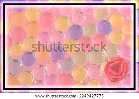 transparent pink frame as copy space, under the frame colorful transparent balls, craft paper rose in the corner of the frame, creative frame for women's day