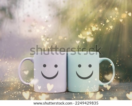 Happy similing face, mug couple on a window sill cuddle, cup of coffee with hearts, relationship and friendship concept, valentines day Royalty-Free Stock Photo #2249429835