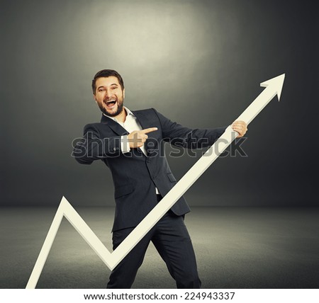 excited businessman pointing at white pointer and laughing. photo in the dark room