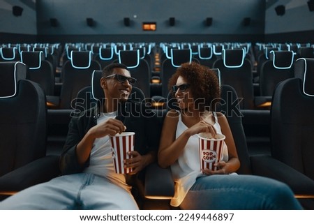 A couple in love watching a movie. Watching a movie in a cinema with popcorn and 3D glasses. High quality photo