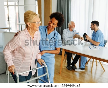 Doctor or nurse caregiver with senior woman using walker assistance  at home or nursing home woman with paraplegia and woman with disability person with chronic health condition Royalty-Free Stock Photo #2249449163