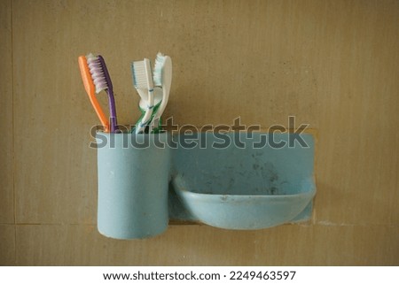 a container for toothbrushes, toothpaste and soap on the wall in the bathroom
