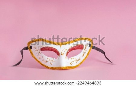Carnival. Festive face mask on a pink background. Mardi gras carnival background with carnival masks. 