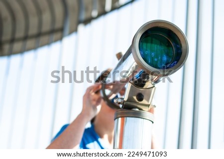 Woman looking through a telescope from the tower Royalty-Free Stock Photo #2249471093