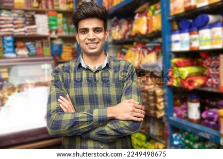 Portrait of smiling handsome young Indian man standing cross arm at grocery shop or supermarket, Closeup. Selective Focus. Royalty-Free Stock Photo #2249498675