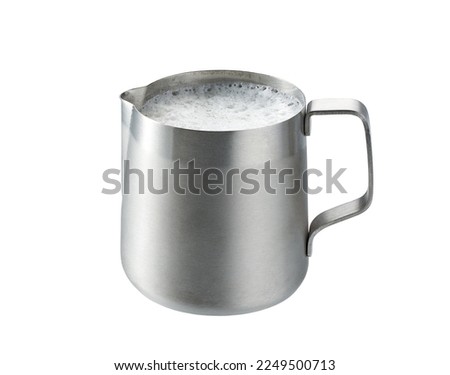 Stainless steel pitcher with whipped milk isolated on white background . stainless steel milk pitcher (foaming jugs) isolated on white background with clipping path. Royalty-Free Stock Photo #2249500713