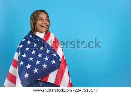 African woman looking aside wrapped in a North American flag