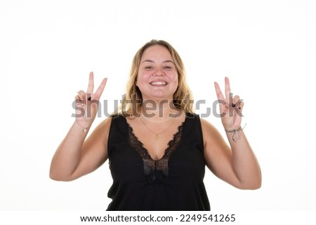 Young beautiful chubby woman on  isolated white background doing peace symbol with fingers over face smiling cheerful showing victory sign