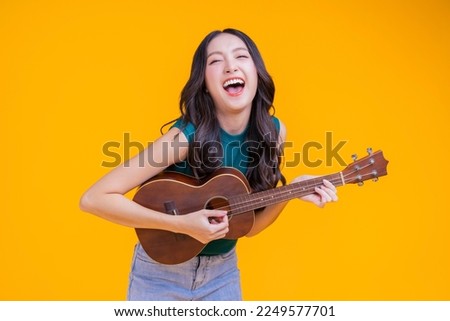 ready to party cheerful asian female woman signing joy fun toothy smile big laugh wearing casual cloth freshness action pose pretending perform in concert studio shot on yellow background