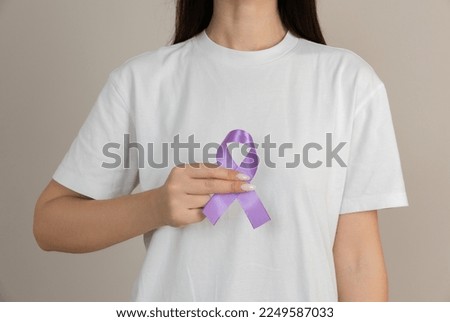 Woman holding a purple ribbon in her hands ADD,ADHD,Alzheimer Disease ,Arnold Chiari Malformation,Childhood Hemiplegia stroke, Epilepsy, Chronic Acute Pain,Crohns Royalty-Free Stock Photo #2249587033