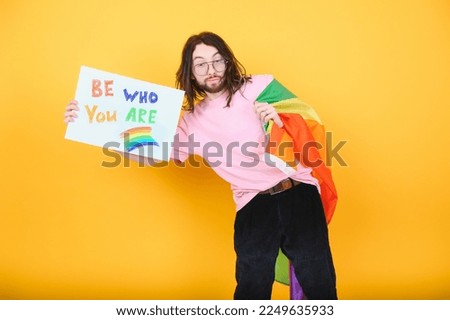 Hands of gay man holding lgbt banner on rainbow flag background lgbt symbol.