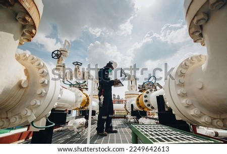 Male worker inspection at steel long pipes and pipe elbow in station oil factory during refinery valve of visual check record pipeline oil. Royalty-Free Stock Photo #2249642613