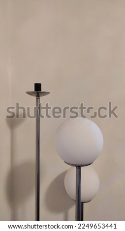 Photo of a round corner lamp in the corner of the white room