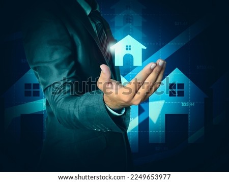 A glowing house hovering in a businessman hand, real estate and property concept background. Investing in property and buying a house backdrop
