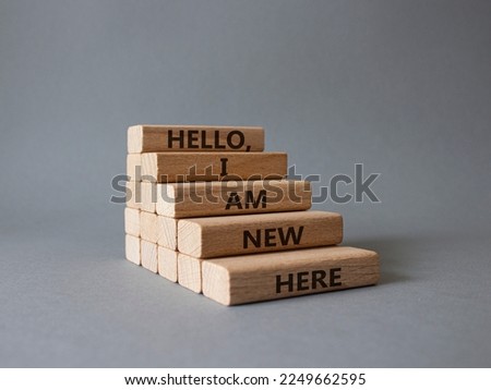 Hello I am new here symbol. Concept words Hello I am new here on wooden blocks. Beautiful grey background. Business and Hello I am new here concept. Copy space.