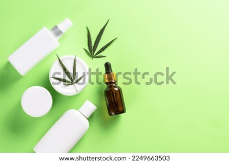 Cannabis cosmetic products. Natural cosmetic. Cream, soap, serum and others. Flat lay image on green background with copy space.