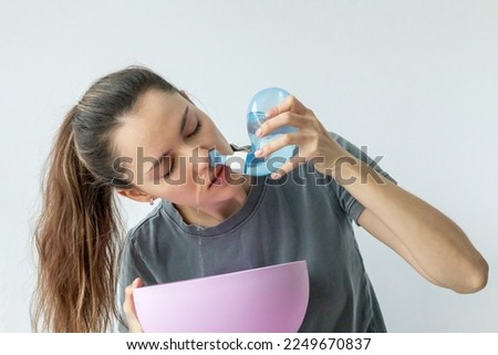 Nasal irrigation. A young girl uses the Neti Pot to treat her runny nose and colds. Nasal lavage, irrigation therapy. Royalty-Free Stock Photo #2249670837