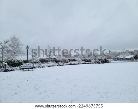 A park area that is covered in snow on a winter day.