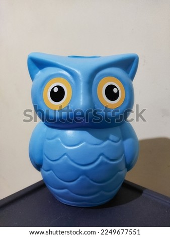 blue piggy bank in the shape of an owl