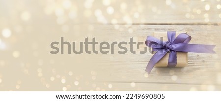  Gift box with purple bow and bokeh lights. Happy Birthday, Mother's Day or Wedding card with copy space